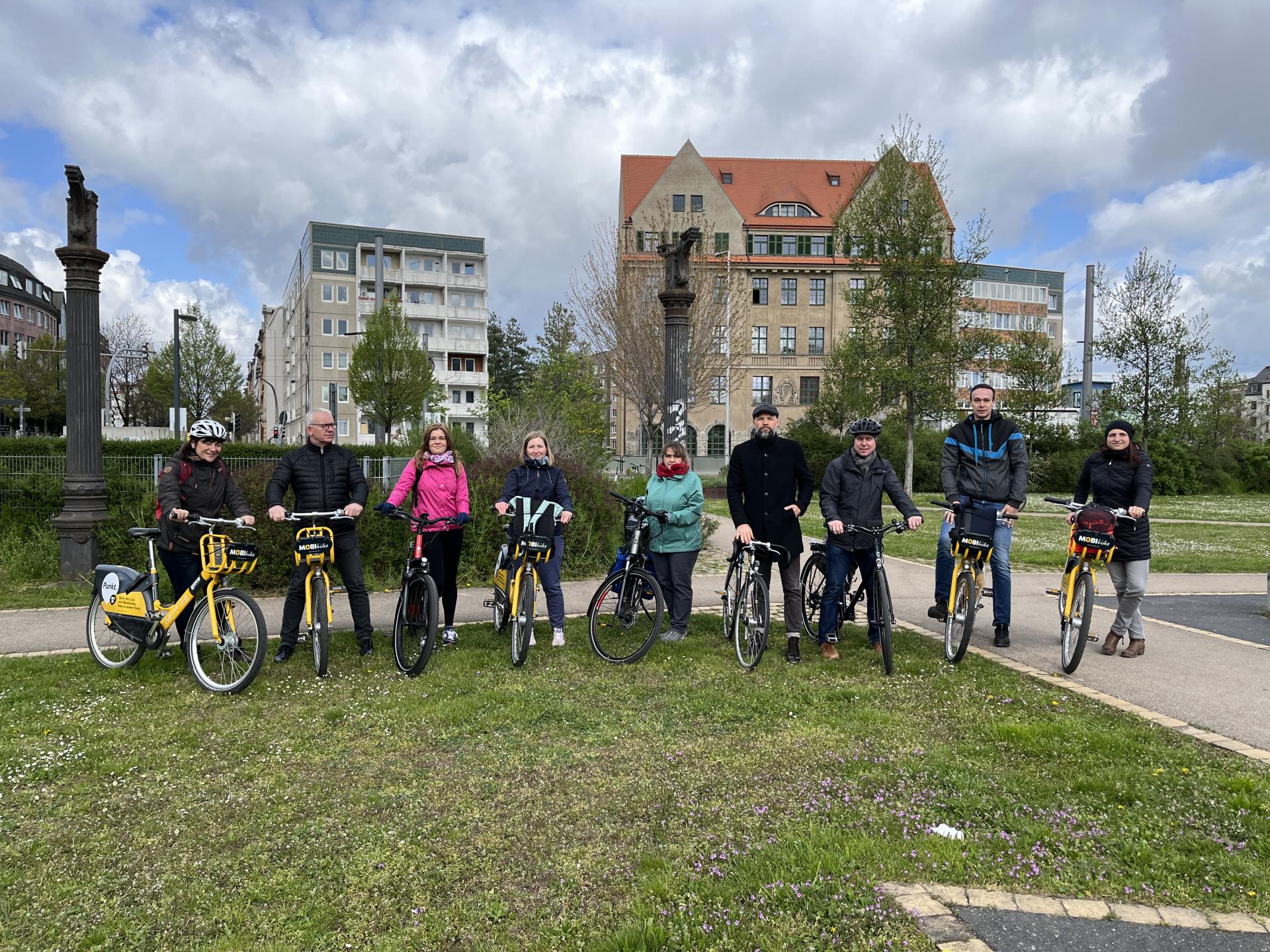 Personen mit Fahrrädern stehen nebeneinander.