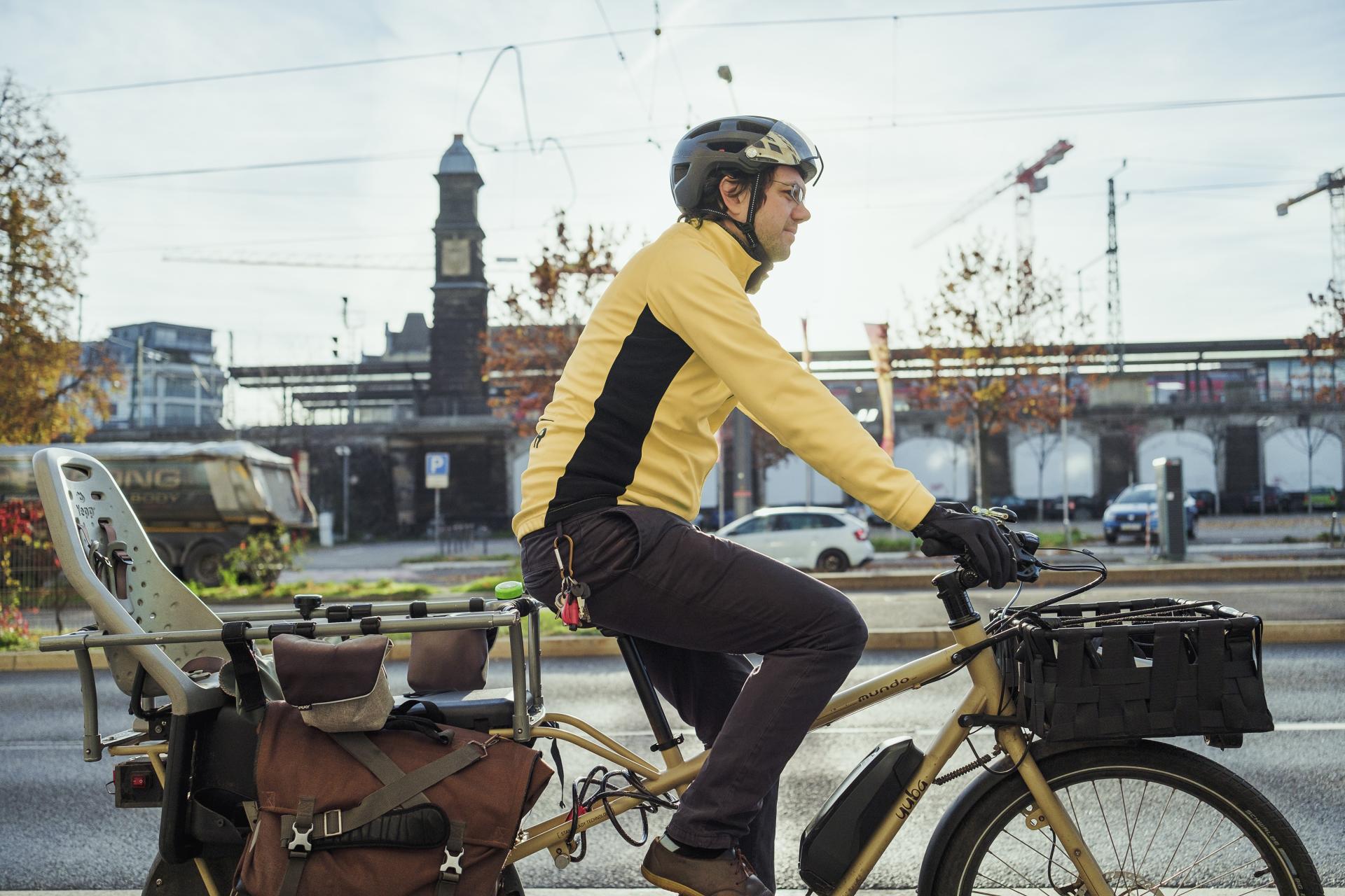 Ein Mann fährt auf einem Lastenrad.