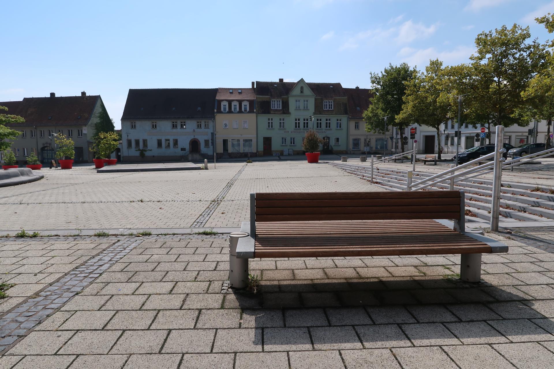 Eine Parkbank steht am Rande des Marktplatzes in Schkeuditz.