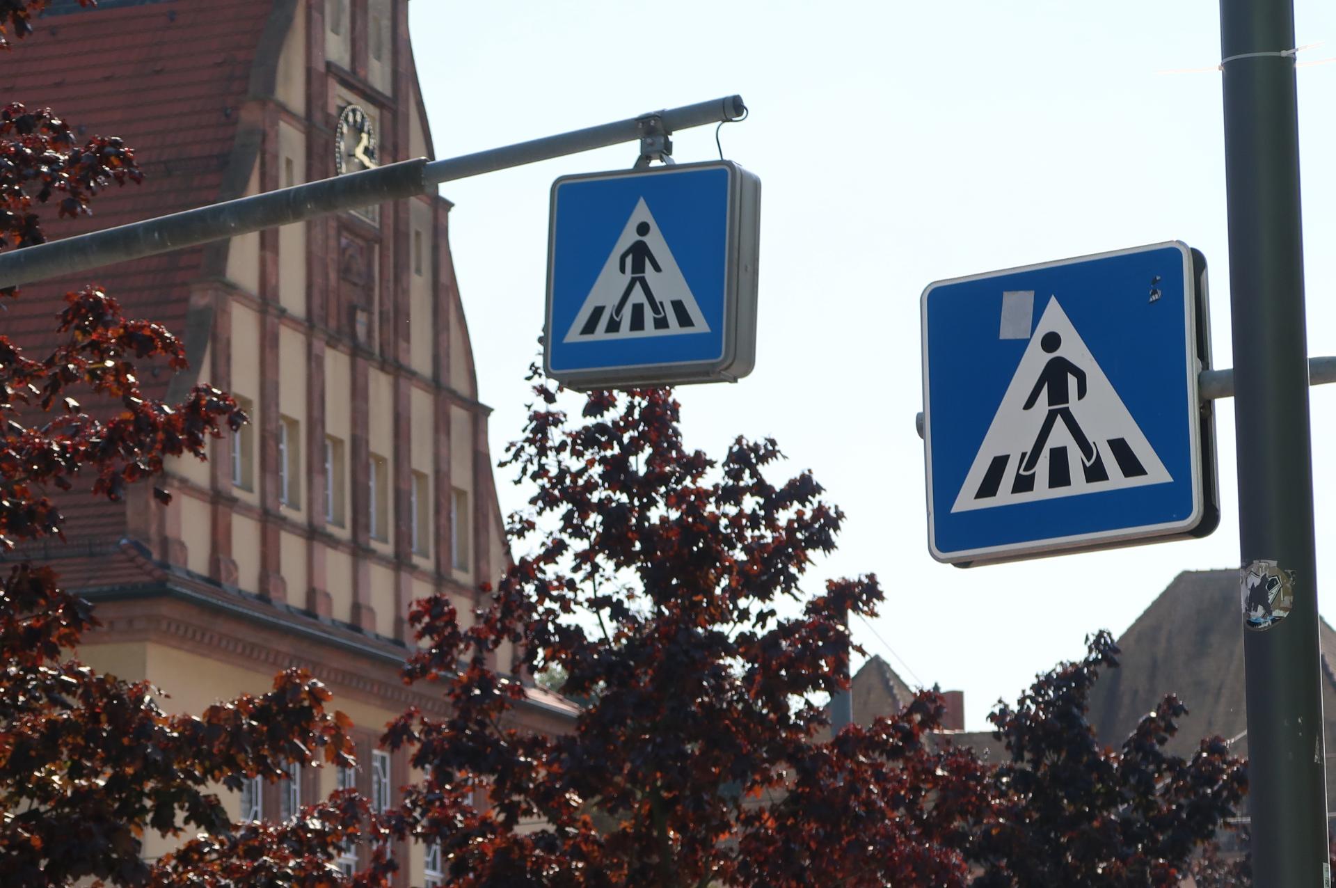 Zebrastreifen-Schild in Nahaufnahme. Im Hintergrund das Rathaus von Schkeuditz.