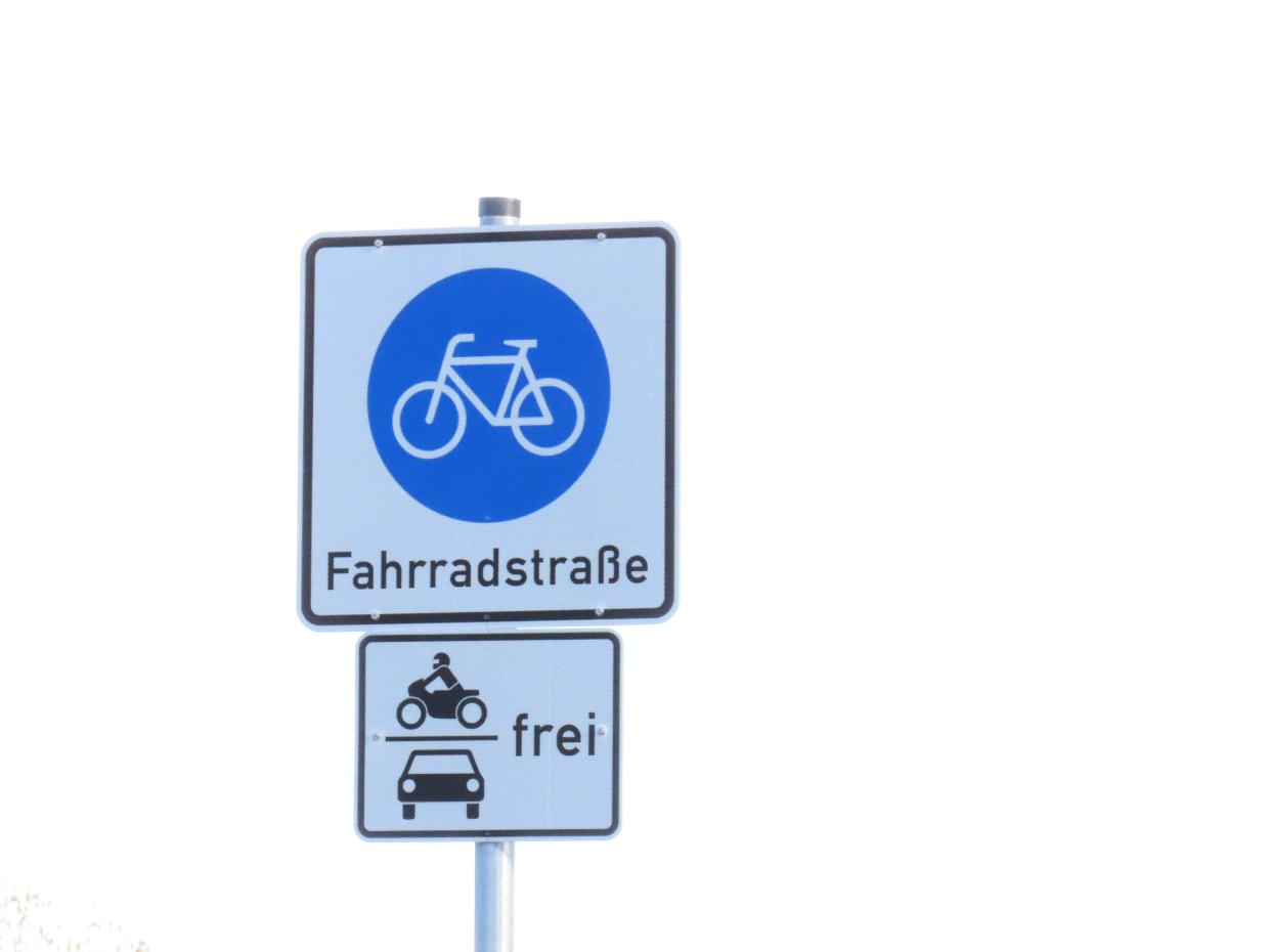 Ein Verkehrsschild mit dem Symbol Fahrradstraße und einem Zusatzzeichen "frei für motorisierten Verkehr".